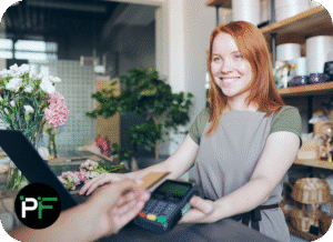 An employee processing a card transaction at checkout, representing the efficiency and security of modern ecommerce software development.