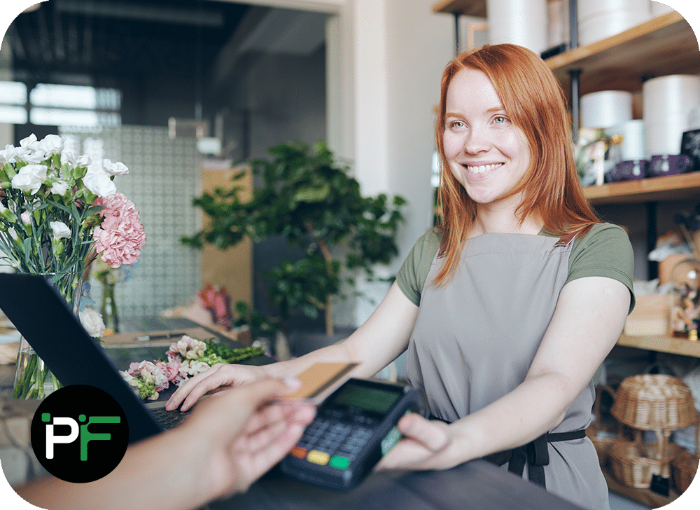 An employee processing a card transaction at checkout, representing the efficiency and security of modern ecommerce software development.